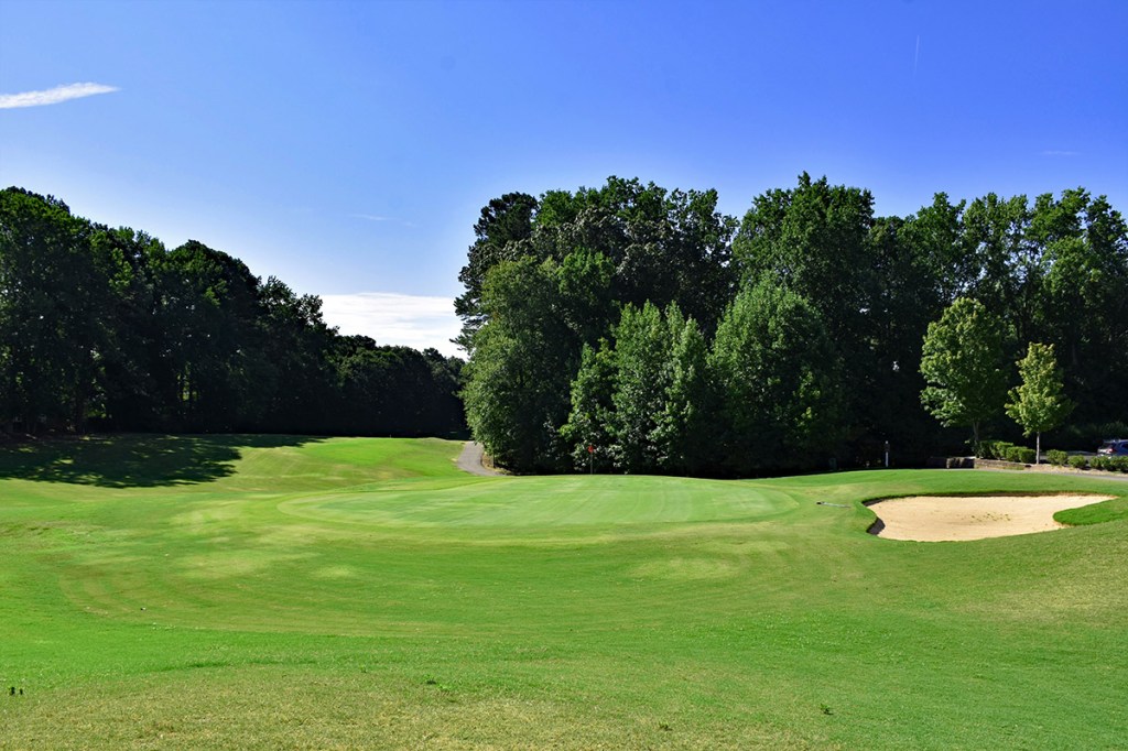 Course greens with lush greens and blue sky in the background