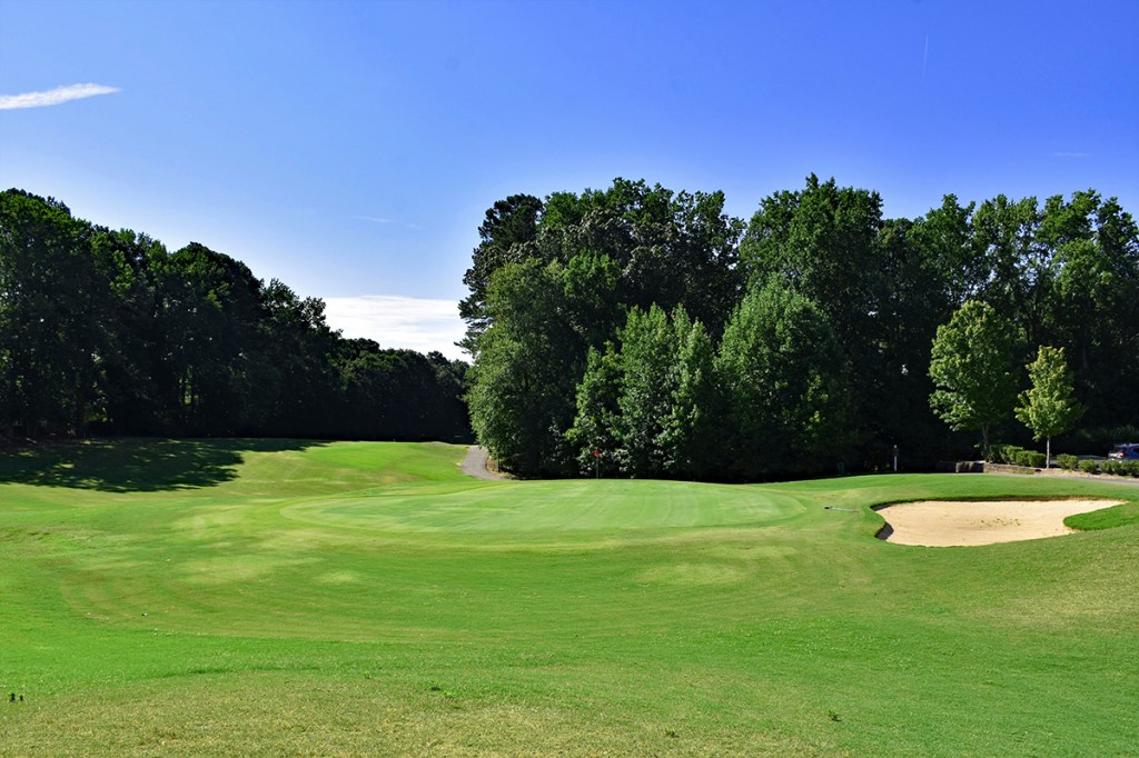 Course greens with lush greens and blue sky in the background 